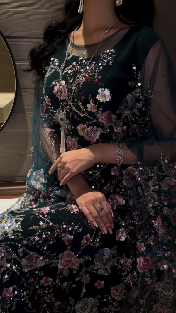 Hand embroidery on the sleeves and chest, featuring sparkling golden details.