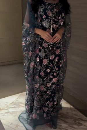 Black gown with crisscross straps, with attached embellished cape.