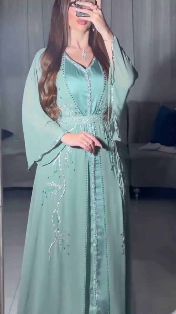 Light blue Moroccan kaftan with cape sleeves, adorned with embellishment.